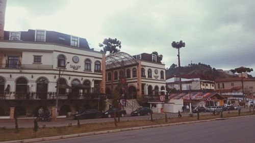 Street by buildings in town against sky