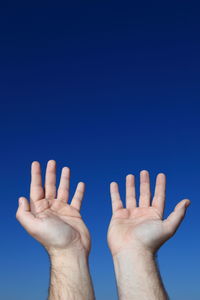 Cropped image of hand holding white background
