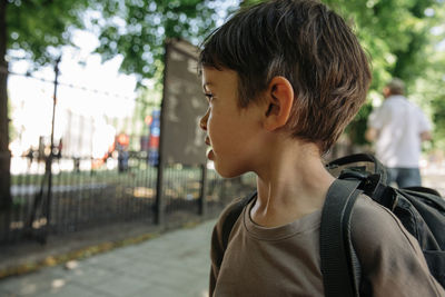 Thoughtful boy looking away wearing backpack