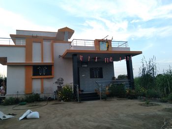 Exterior of house by building against sky