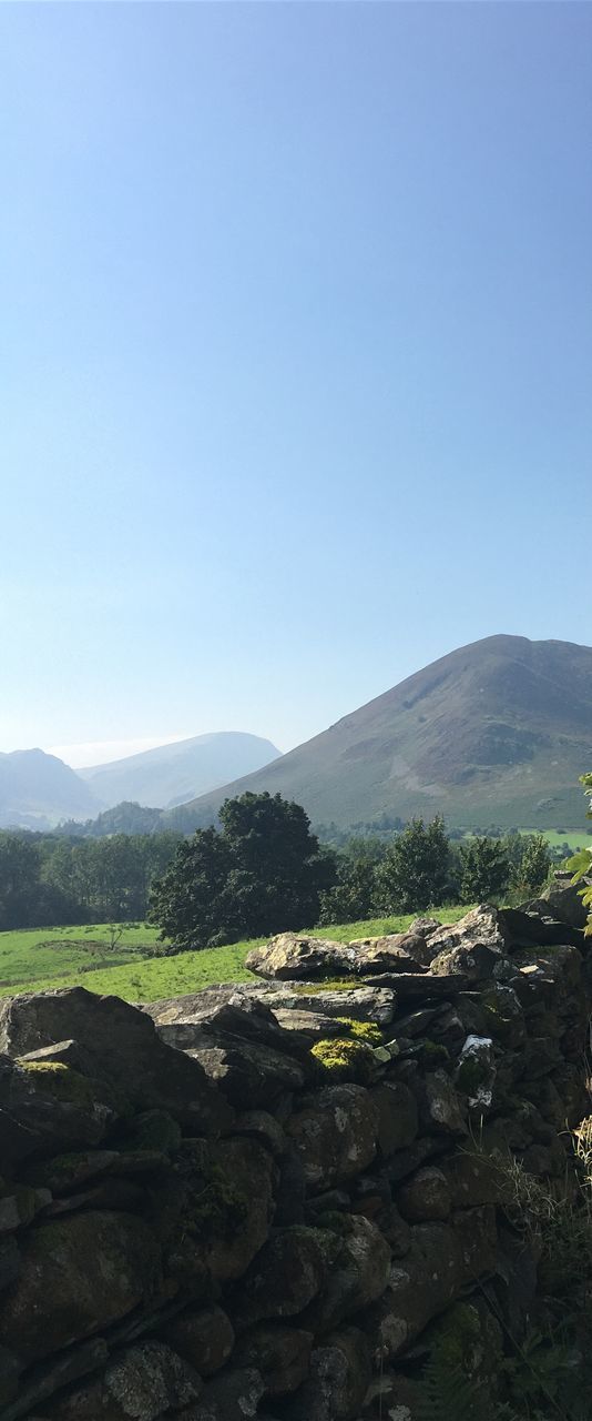 scenics, nature, mountain, beauty in nature, blue, idyllic, no people, tranquility, agriculture, tranquil scene, clear sky, sky, tree, growth, outdoors, rural scene, day, landscape, water, lush - description