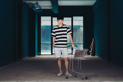 Portrait of young man standing in corridor