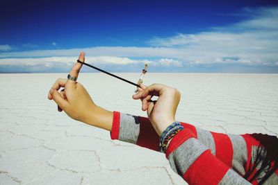 Optical illusion of woman aiming slingshot with man at salar de uyuni