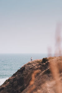 Man looking at sea against clear sky