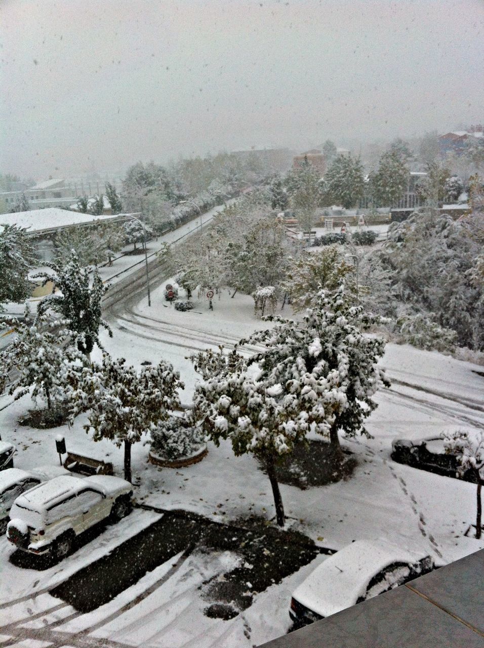 high angle view, snow, winter, built structure, transportation, cold temperature, road, season, tree, building exterior, architecture, city, street, weather, nature, outdoors, day, sky, no people, car