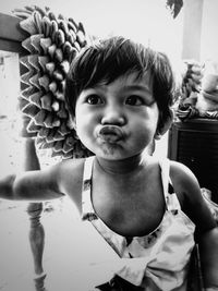 Close-up of cute girl making face at home