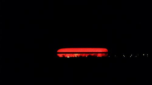 Close-up of illuminated red light against black background