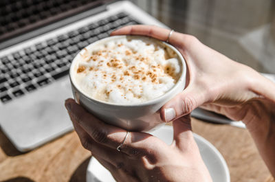 Midsection of woman holding coffee cup