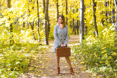 Portrait of smiling young man standing in park during autumn