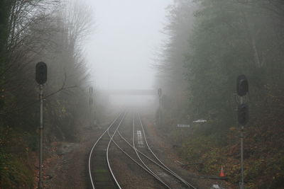 Railroad tracks against sky during foggy weather