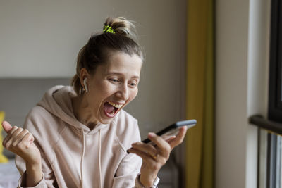 Side view of boy using mobile phone at home