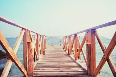 Wooden footbridge against clear sky