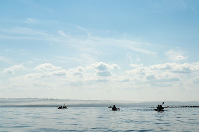 People on sea against sky