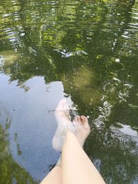 Low section of woman sitting on swimming pool