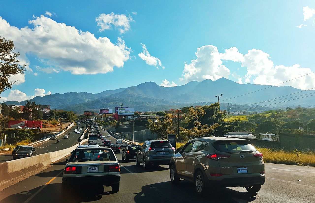 car, transportation, mode of transport, traffic, travel, city, sky, cloud - sky, city life, driving, night, rush hour, outdoors, no people, mountain