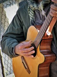 Midsection of man playing guitar