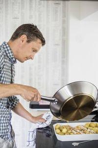 Side view of man preparing food in kitchen