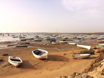 Boats moored on beach against sky