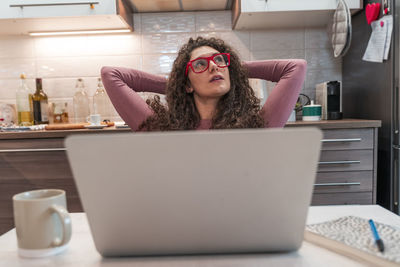 Portrait of young woman using laptop at home