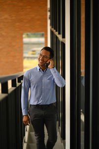 Portrait of young man standing against wall