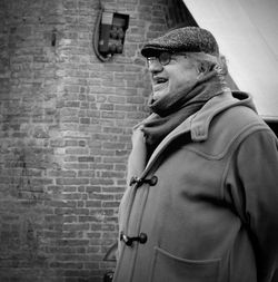 Midsection of man standing against brick wall