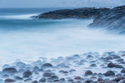 Rocks in sea against sky