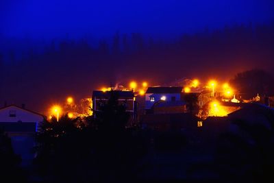 Illuminated buildings against sky at night