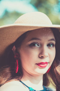 Close-up portrait of beautiful young woman wearing hat