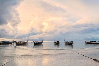 Boats moored on sea against sky