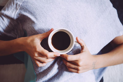 Close-up of cropped hand holding coffee cup