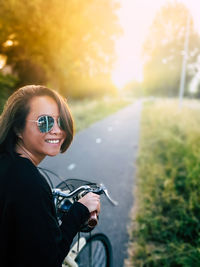 Portrait of smiling young woman riding motorcycle on road