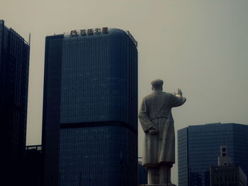 Low angle view of statue in city against clear sky