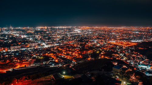 High angle view of illuminated cityscape against sky at night