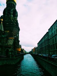 Statue in city against cloudy sky