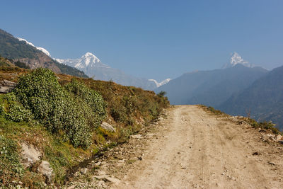 Road amidst mountains against clear sky