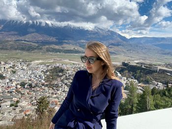 Woman sitting against mountains and sky