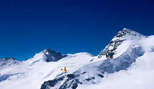 Airplane surrounded by snowcapped mountain