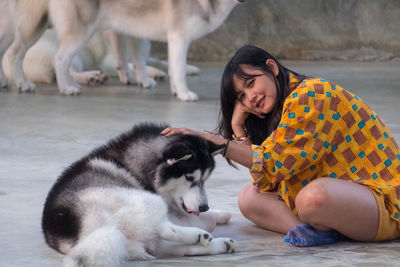 Mid adult woman with siberian husky sitting outdoors