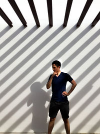 Young man standing against wall