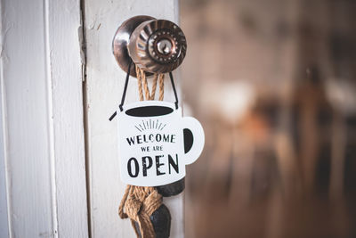 Close-up sign board hanging on door of cafe