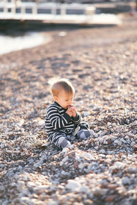 Full length of cute boy on pebbles