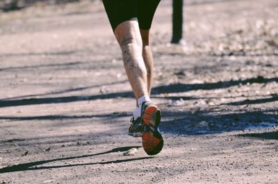 Low section of man running on land