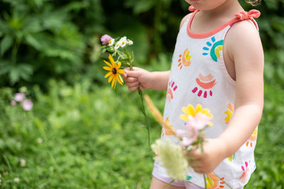 Midsection of girl holding flowers