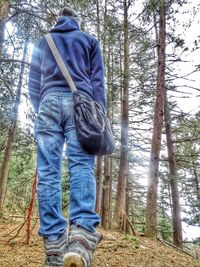 Man standing on tree in forest