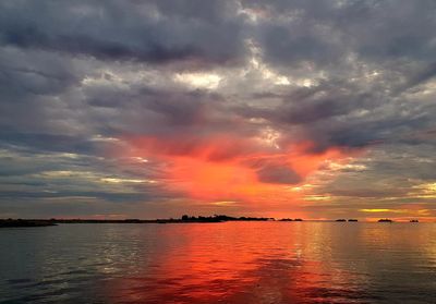 Scenic view of sea against dramatic sky during sunset