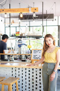 Portrait of smiling young woman standing on table