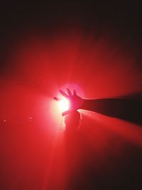 Close-up of illuminated red light against sky at sunset