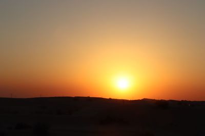 Scenic view of silhouette landscape against orange sky