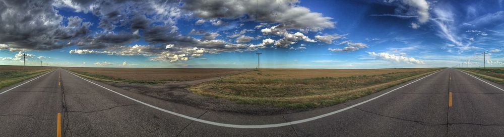 Country road against cloudy sky