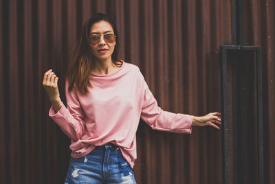 Portrait of young woman wearing sunglasses standing outdoors